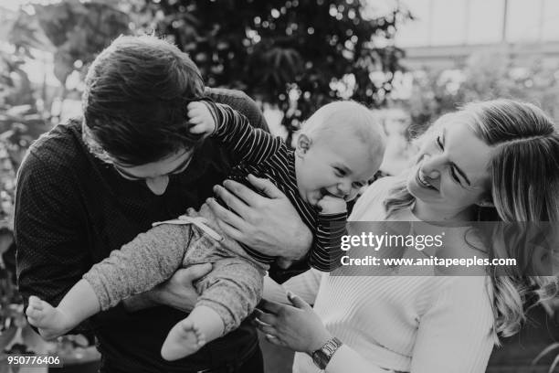 baby boy, mother, father sitting together in tropical setting - www photo com stock pictures, royalty-free photos & images