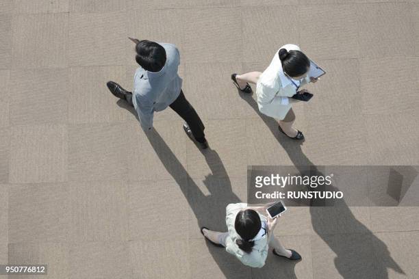 high angle view of business people walking - people walking overhead view stock pictures, royalty-free photos & images