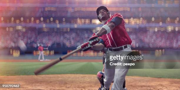 battitore di baseball professionista che colpisce palla durante la partita notturna allo stadium - batting foto e immagini stock