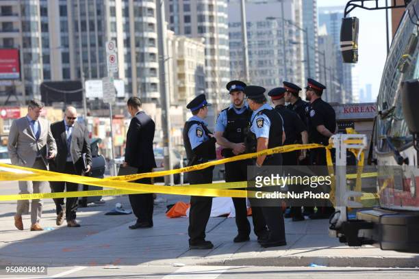 Body lies on the pavement covered in an orange tarp after 10 people were killed and 15 people injured in a deadly van attack in Toronto, Ontario,...