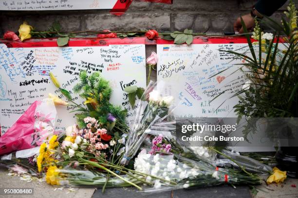 Messages written in different languages can be seen through flowers strewn on a memorial for victims of yesterday's crash on Yonge St. At Finch Ave....