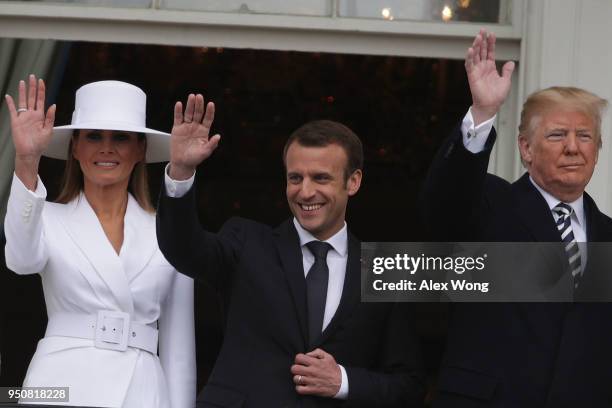 President Donald Trump , first lady Melania Trump , and French President Emmanuel Macron wave from the Truman Balcony of the White House during a...