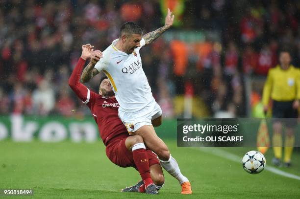 Liverpool's English midfielder Alex Oxlade-Chamberlain picks up an injury tackling Roma's Croatian defender Aleksandar Kolarov during the UEFA...