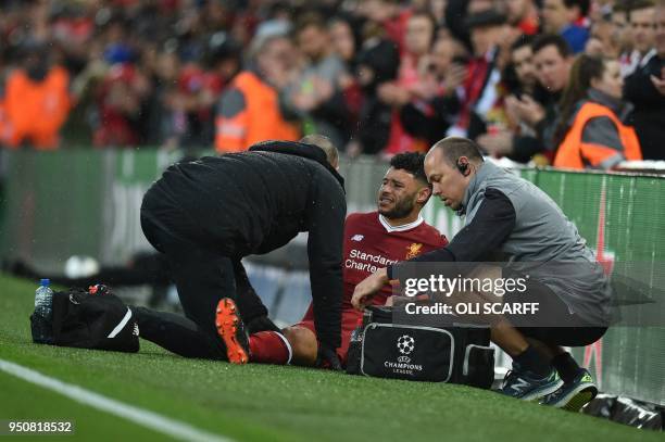 Liverpool's English midfielder Alex Oxlade-Chamberlain picks up an injury during the UEFA Champions League first leg semi-final football match...