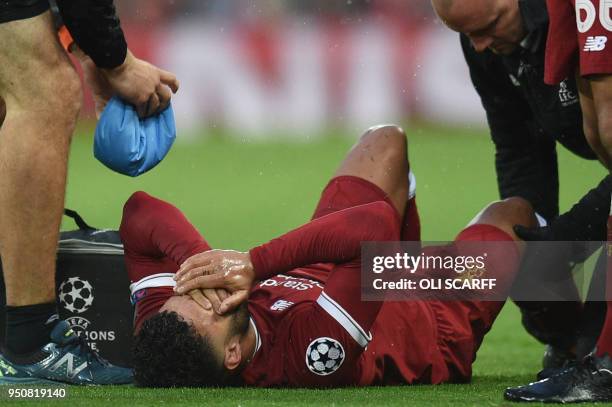 Liverpool's English midfielder Alex Oxlade-Chamberlain reacts after picking up an injury during the UEFA Champions League first leg semi-final...