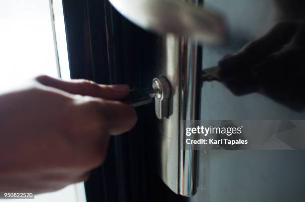 a man is holding a key to open the lock door - unlocking door stock pictures, royalty-free photos & images