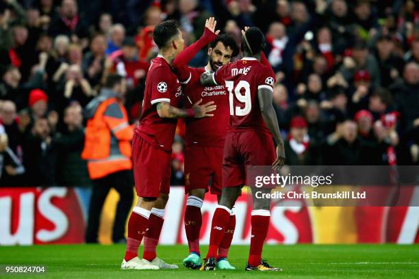 Mohamed Salah of Liverpool celebrates with teammates Roberto Firmino and Sadio Mane after scoring his sides first goal during the UEFA Champions...