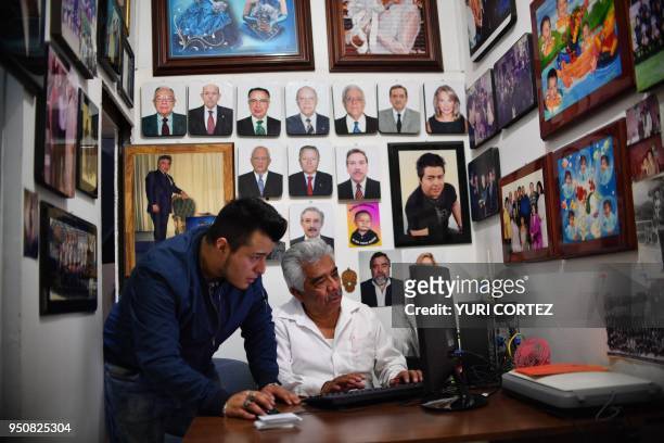 Mexican photographer Cesar Arizmendi and his son Uriel work at their photo studio in Mexico City on April 20, 2018. - Arizmendi, who is the father of...