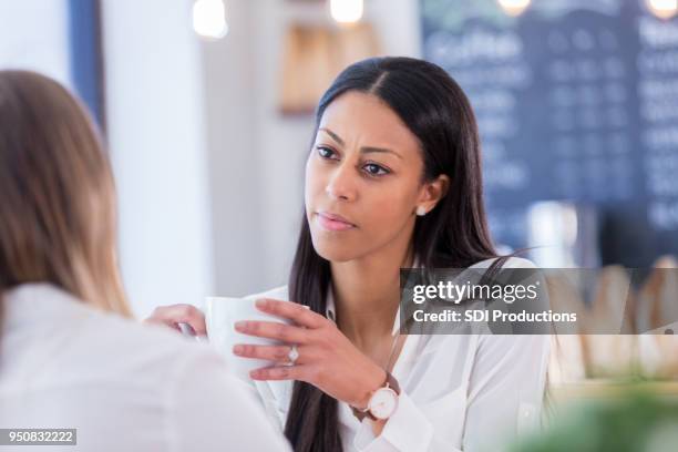 betrokken jonge vrouw praat met vriend in coffeeshop - coffee meeting with friends stockfoto's en -beelden