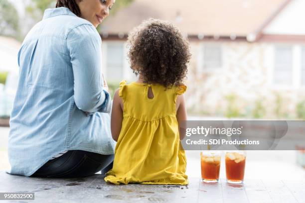 moeder en dochter genieten van ijsthee op hun veranda - back porch stockfoto's en -beelden