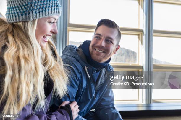 young couple take a break in ski lodge - ski jacket stock pictures, royalty-free photos & images