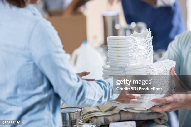 unrecognizable volunteers organize diapers at local food bank - adult diaper stock pictures, royalty-free photos & images