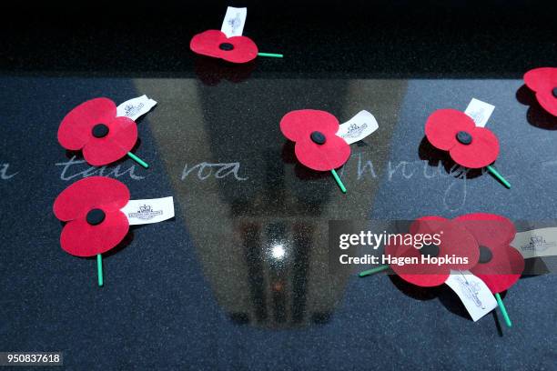 The carillon is reflected in amongst poppies on the Tomb of the Unknown Warrior during the Anzac Day Dawn Service at Pukeahu National War Memorial...