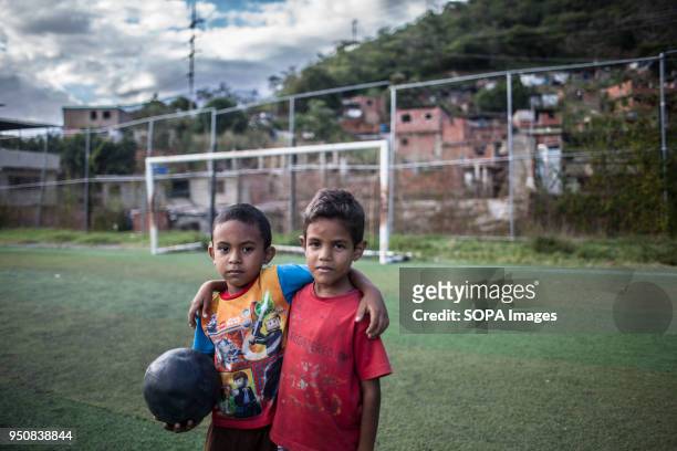 Two young boys seen taking a pose while playing football. Passion Petare is an association from the favelas of Petare in Caracas to help young...