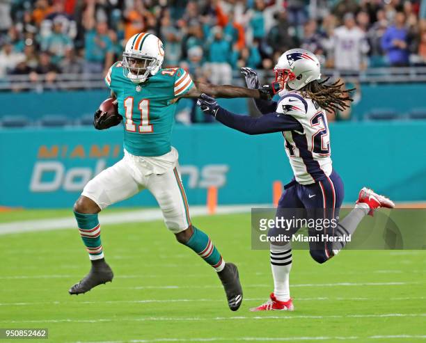 Miami Dolphins' DeVante Parker catches a first quarter pass as New England Patriots'Stephan Gilmore defends at Hard Rock Stadium Monday, Dec. 11,...