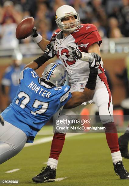 Kurt Warner of the Arizona Cardinals looks to throw a pass while being pursued by Jason Hunter of the Detroit Lions at Ford Field on December 20,...