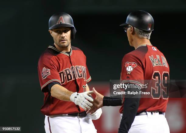 Pollock of the Arizona Diamondbacks slaps hands with first base coach Dave McKay after hitting a single against the San Diego Padres during the...