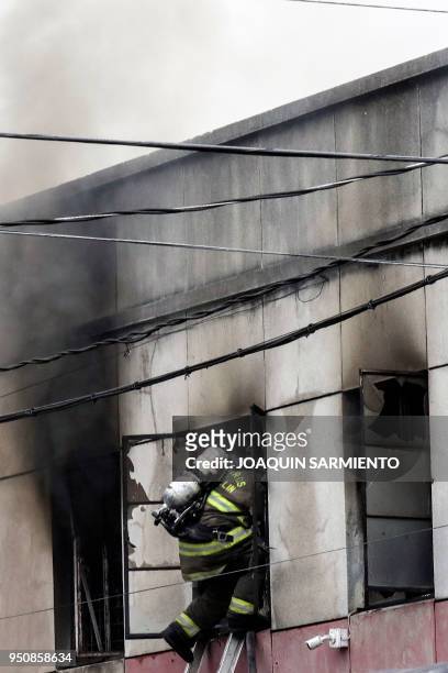 Firefighter works to extinguish a fire at a paint warehouse in Alpujarra district, in Medellin, Colombia on April 24, 2018