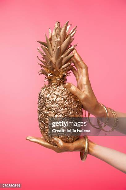 crop hand holding golden pineapple - glitter fruit stock pictures, royalty-free photos & images