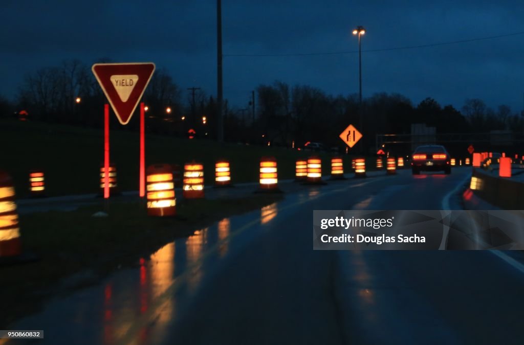 Reflective neon construction barrels along the highway