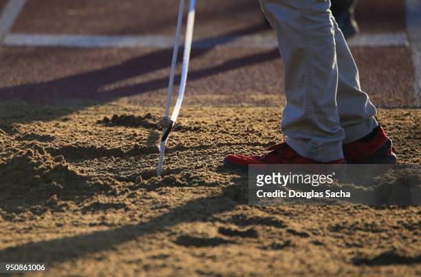 referee measuring the distance in a long jump pit - long jump pit stock pictures, royalty-free photos & images