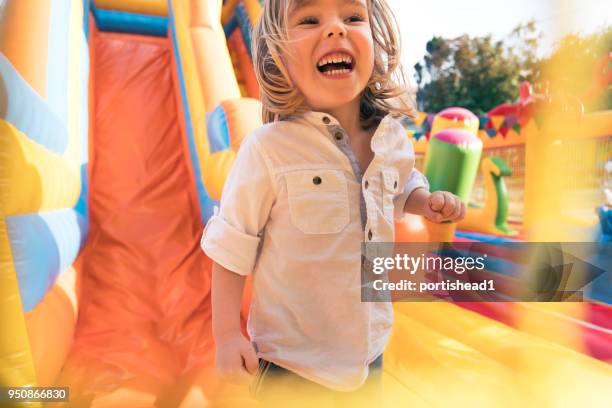 little kid having fun in inflatable castle playground - bouncy castle stock pictures, royalty-free photos & images