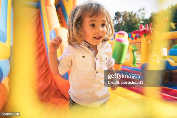 little kid having fun in inflatable castle playground - bounce castle stock pictures, royalty-free photos & images