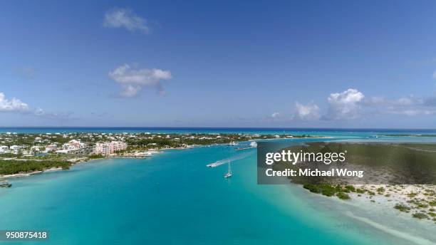 drone aerial of boat traveling through crystal clear blue water in caribbean - providenciales stock pictures, royalty-free photos & images