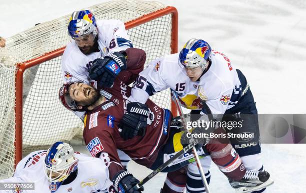 James Sheppard of Eisbaeren Berlin is tackled by players of Red Bull Muenchen during the DEL Playoff final match 6 between Eisbaeren Berlin and EHC...