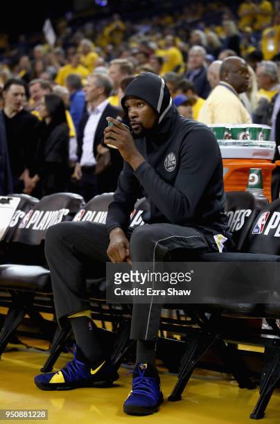 Kevin Durant of the Golden State Warriors sits on the bench before their game against the San Antonio Spurs during Game 2 of Round 1 of the 2018 NBA...