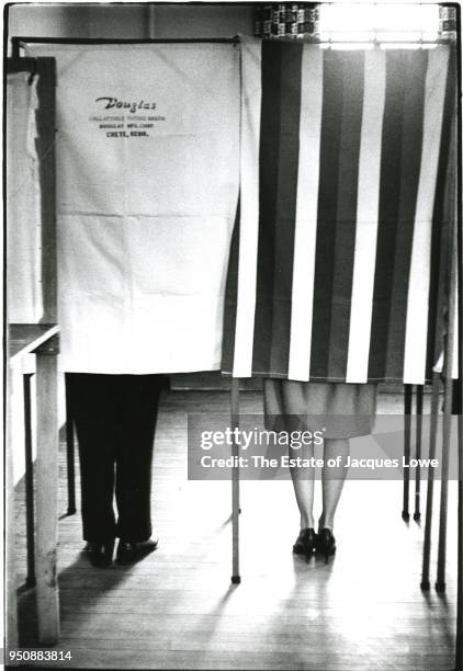 View of the legs of married couple US Attorney General Robert F Kennedy and Ethel Saskel Kennedy in side-by-side booths in the Masonic Hall as they...