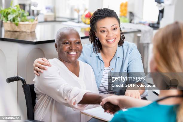 mid adult woman talks with her mom's nurse - rehabilitation meeting stock pictures, royalty-free photos & images
