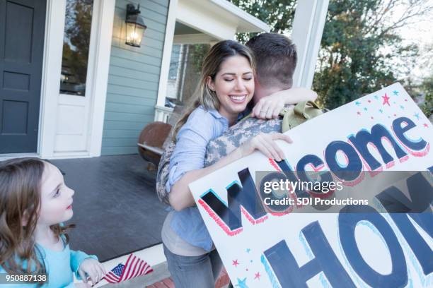 family welcomes soldier dad home from duty - homecoming stock pictures, royalty-free photos & images