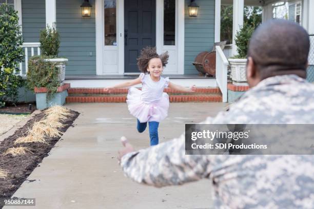 opgewekt meisje loopt te begroeten militaire papa - terugkomdag stockfoto's en -beelden