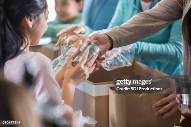 mujer recibe alimentos de banco de alimentos local - food bank fotografías e imágenes de stock