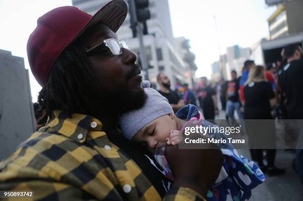 Dwayne Ray, whose wife is Armenian, holds their daughter Kiayah at a rally outside the Turkish Consulate during a march and rally commemorating the...