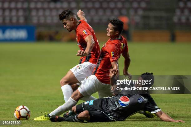 Venezuela's Deportivo Lara defender Daniel Carrilo and midfielder Carlos Sierra vie for the ball with Colombia's Millonarios midfielder David Silva ,...