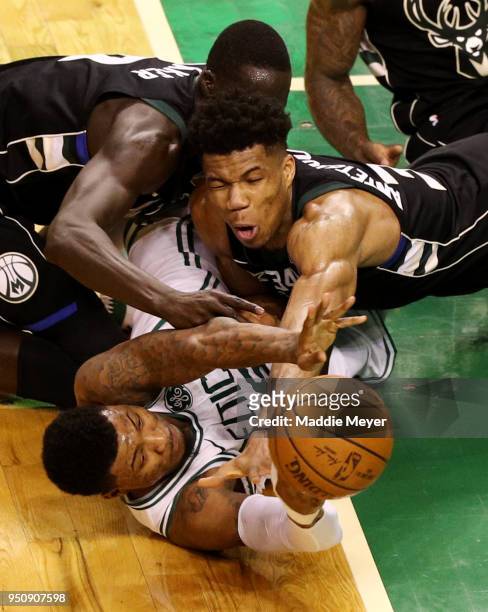 Marcus Smart of the Boston Celtics competes for a loose ball against Giannis Antetokounmpo of the Milwaukee Bucks and Thon Maker during the fourth...
