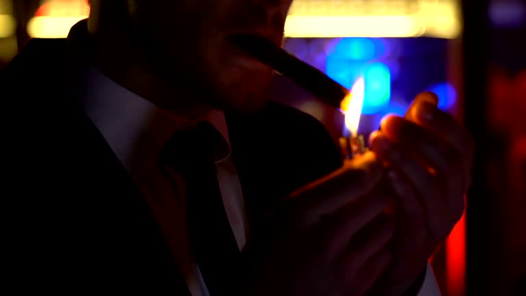 https://media.gettyimages.com/id/950908836/video/confident-man-in-suit-lighting-cigar-relaxing-at-night-party-elite-mens-club.jpg?b=1&s=640x640&k=20&c=fAAP_BcPWo5qV27kdrV0cF-NrW2vhLEmZaJbIKqdEhE=