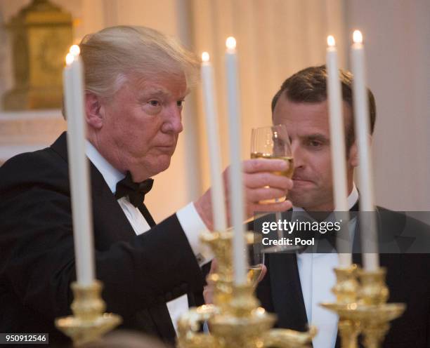President Donald Trump shares a toast with French President Emmanuel Macron during the State Dinner for Macron and French first lady Brigitte Macron...