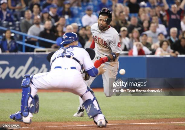 Eduardo Nunez of the Boston Red Sox is thrown out at home plate in the ninth inning during MLB game action as Russell Martin of the Toronto Blue Jays...