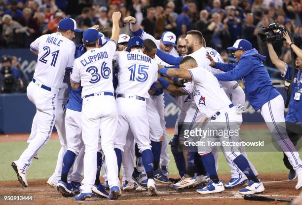 Curtis Granderson of the Toronto Blue Jays is congratulated by teammates after hitting a game-winning solo home run in the tenth inning during MLB...