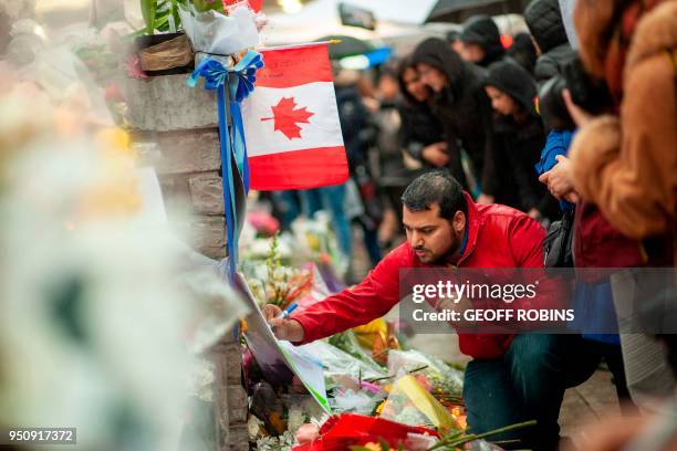 Man writes a message at a memorial near the site of the deadly van attack, April 24, 2018 in Toronto, Ontario. - A van driver who ran over 10 people...