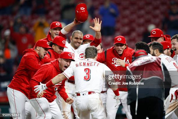 Scooter Gennett of the Cincinnati Reds celebrates with teammates after hitting a game winning two-run home run in the 12th inning against the Atlanta...