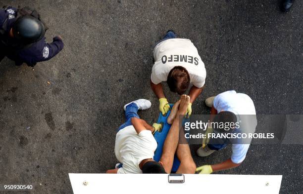 Forensic personnel load the corpse of a man into a van, after he was executed at a shopping mall in Vista Alegre neighborhood in the touristic city...