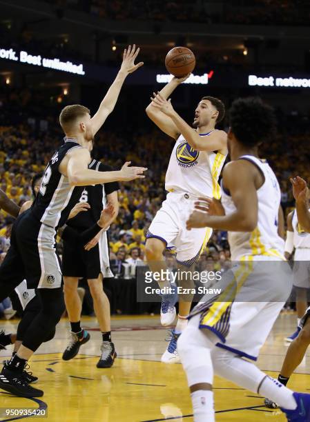 Klay Thompson of the Golden State Warriors shoots over Davis Bertans of the San Antonio Spurs during Game Five of Round One of the 2018 NBA Playoffs...