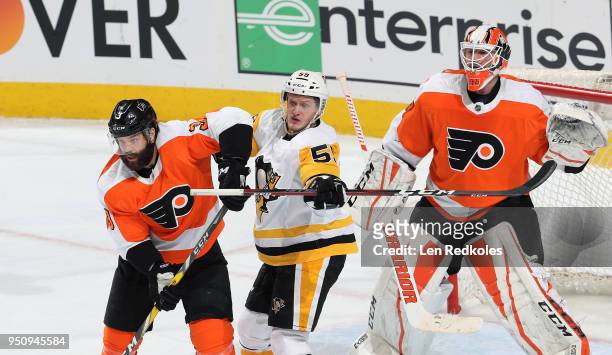 Jake Guentzel of the Pittsburgh Penguins battles on a scoring opportunity against Radko Gudas and Brian Elliott of the Philadelphia Flyers in Game...