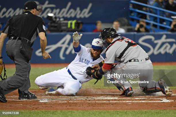 Toronto Blue Jays Catcher Russell Martin is tagged out at home plate by Boston Red Sox Catcher Sandy Leon during the regular season MLB game between...