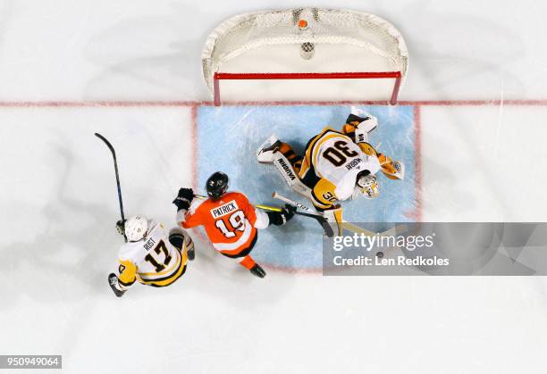 Nolan Patrick of the Philadelphia Flyers battles for the puck in the crease against Matthew Murray and Bryan Rust of the Pittsburgh Penguins in Game...