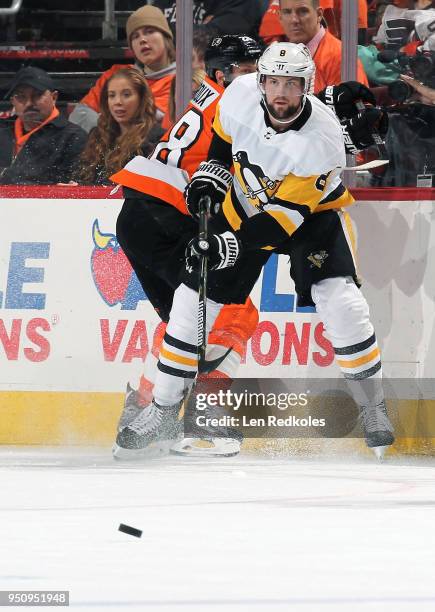 Brian Dumoulin of the Pittsburgh Penguins passes the puck against Claude Giroux of the Philadelphia Flyers in Game Four of the Eastern Conference...